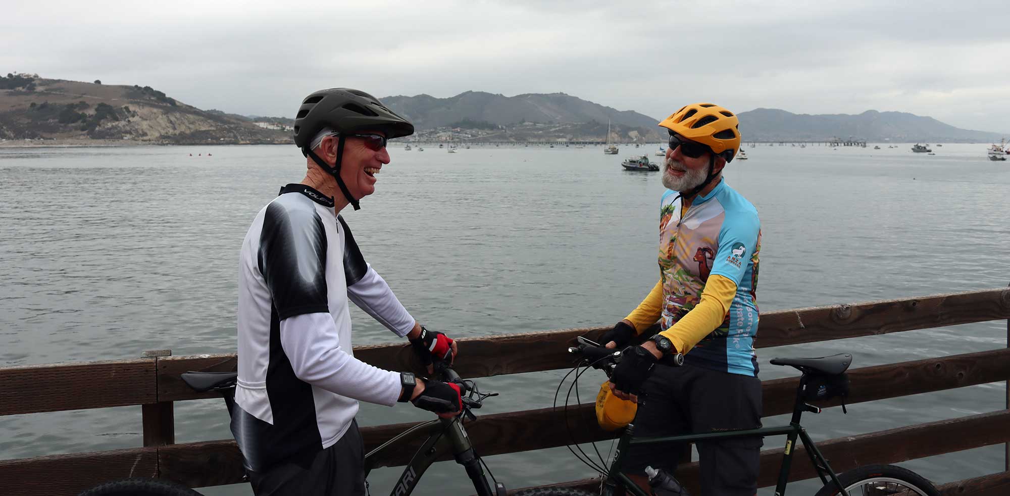 A cyclist with hearing loss in conversation on a bridge overlooking the bay.